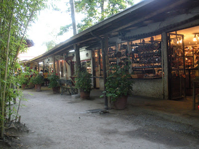Small shops with shade overhead and sidewalk in the foreground
