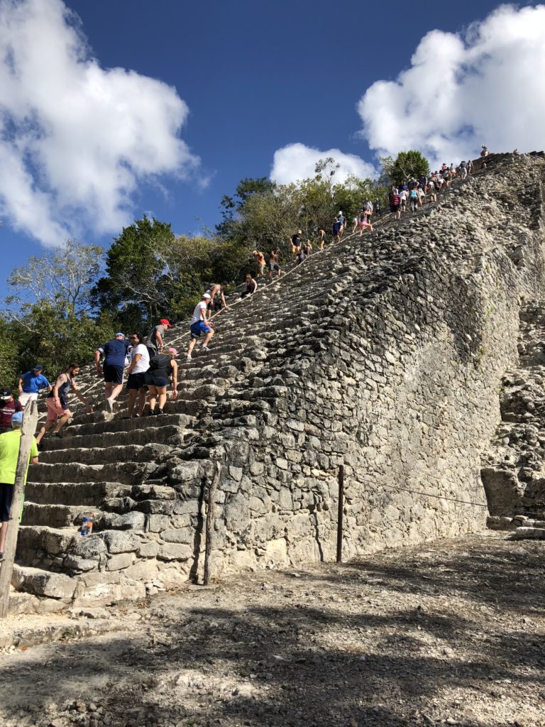 tourist climbing up and going down the pyramid at Coba